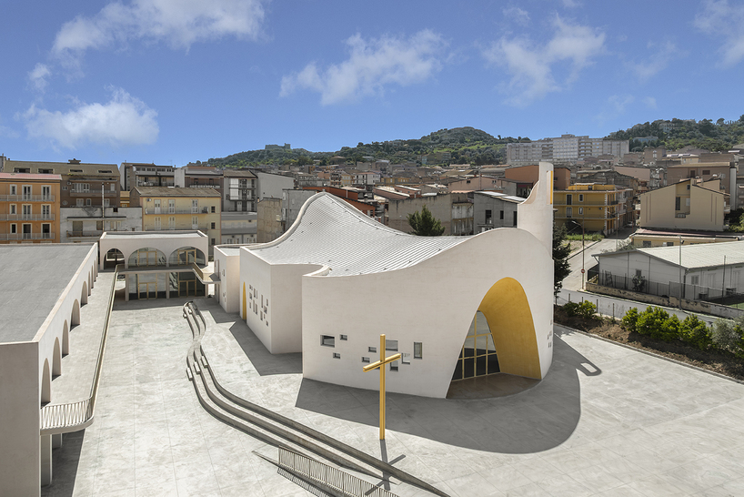 The parish complex read as a campus: church, chapel, classrooms and rectory arranged around open ground