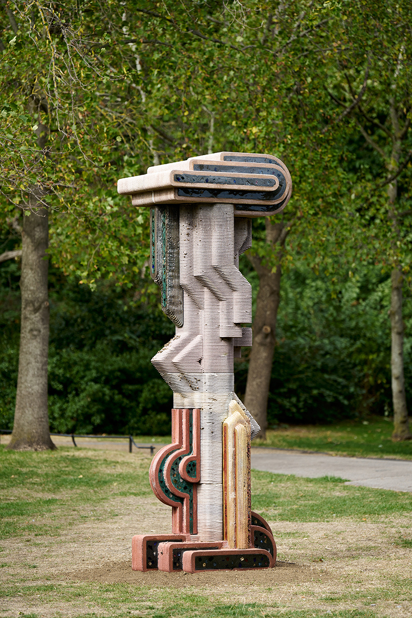 The printed rings climbing the figure, with the pigment changing as it goes