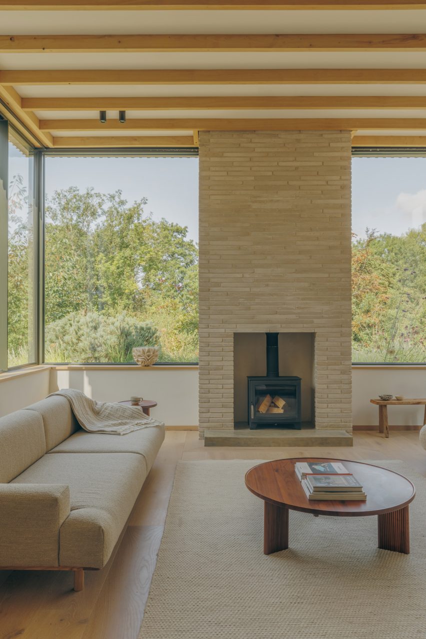 A wood-burning stove set into a floor-to-ceiling fireplace, laid in the same brick as the facade.