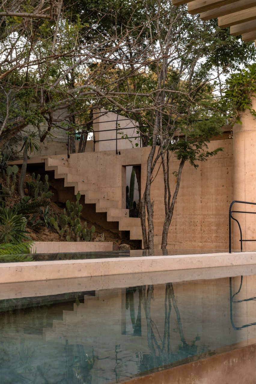 A rooftop terrace with a shallow pool, the pigmented concrete warm against the sky