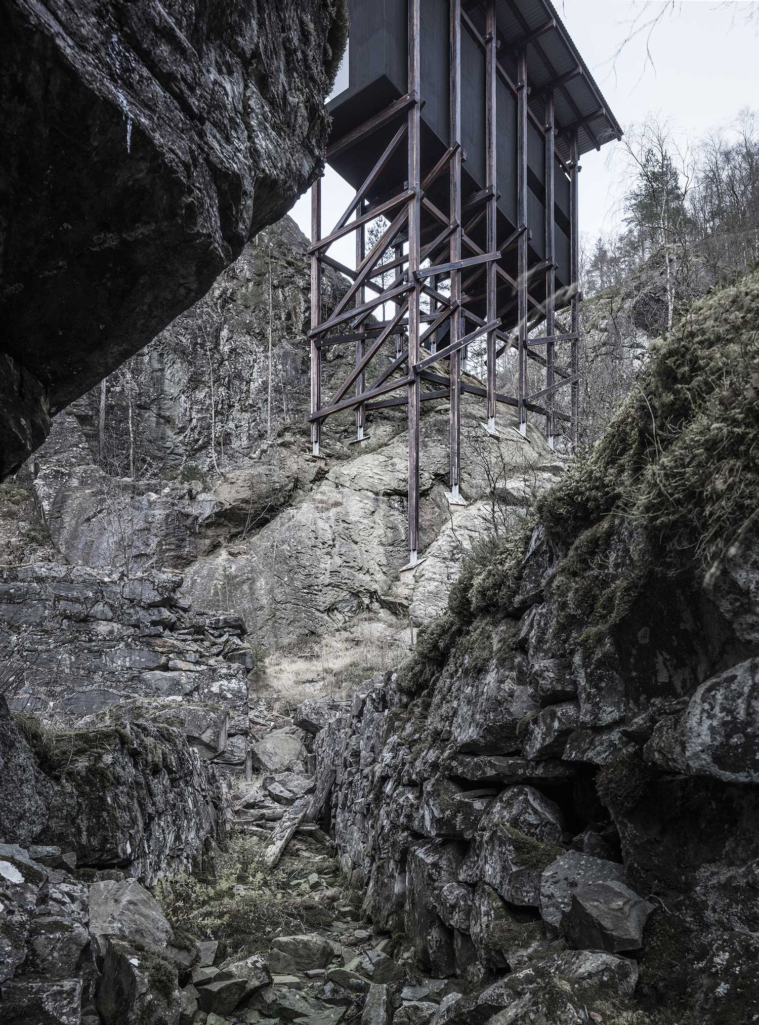 Under the scaffold: timber posts footed on the rock. Photography via Yellowtrace