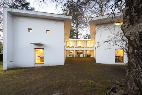 The pavilion from the grounds at dusk, the blank outer wall and the thin roof plane
