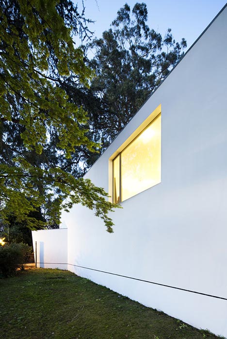 A studio window cut into the tilted end wall, lit from inside